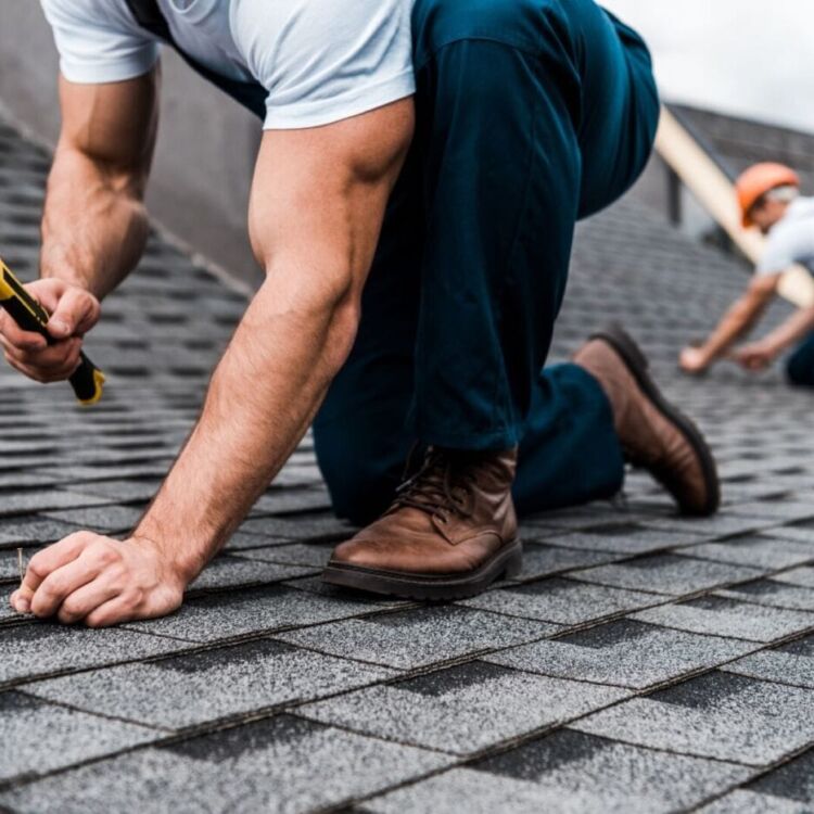 cropped view of repairmen in uniform working on rooftop