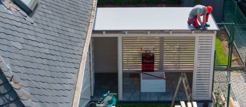 Worker Installing Roof On Patio Structure